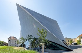 Landesgalerie Niederösterreich, © Raffael F. Lehner Moderne Architektur der Landesgalerie Niederösterreich mit schrägen Linien und Glasfassade.