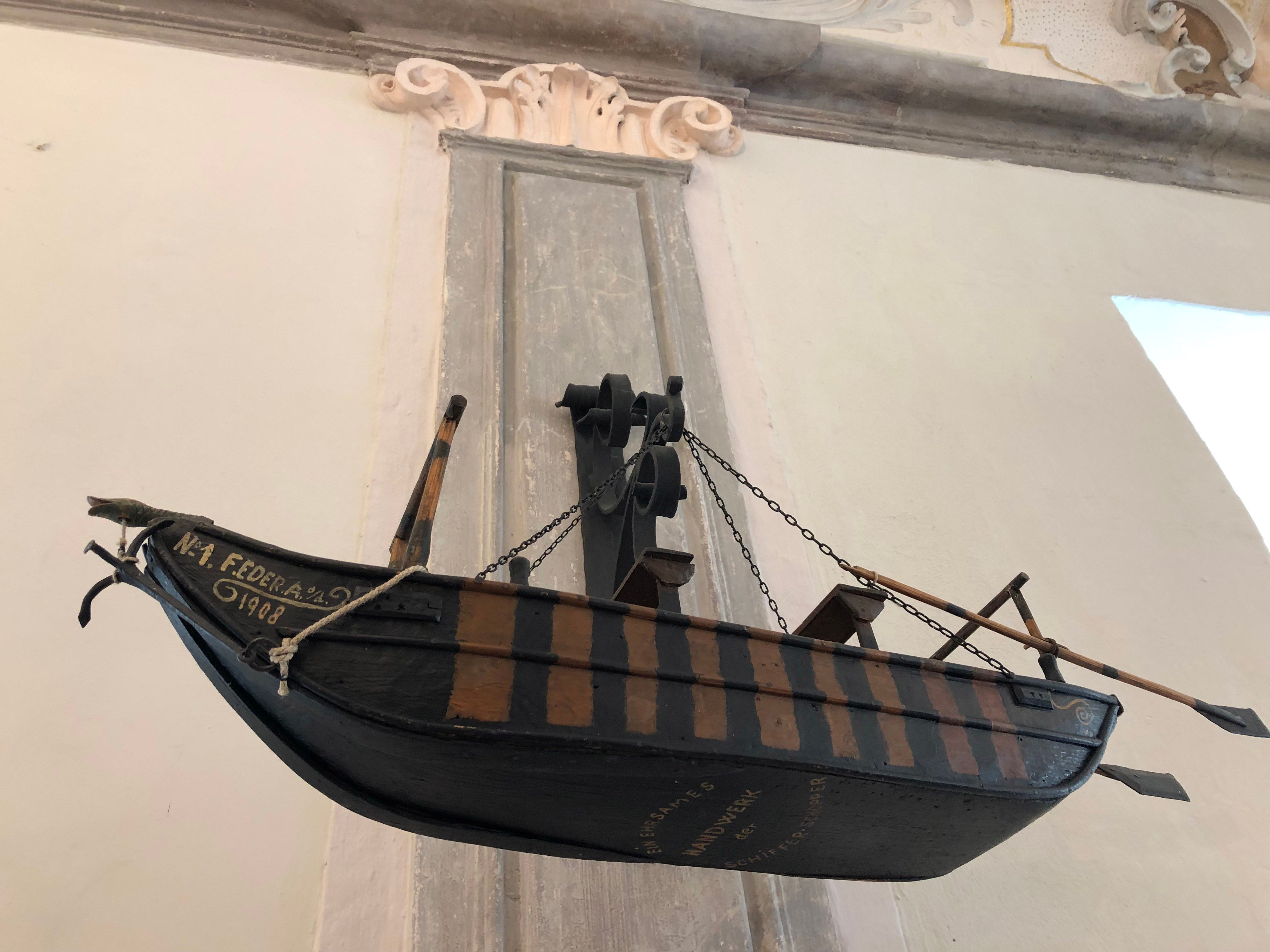 Modell eines historischen Ruderbootes an der Wand eines Museums ausgestellt.
