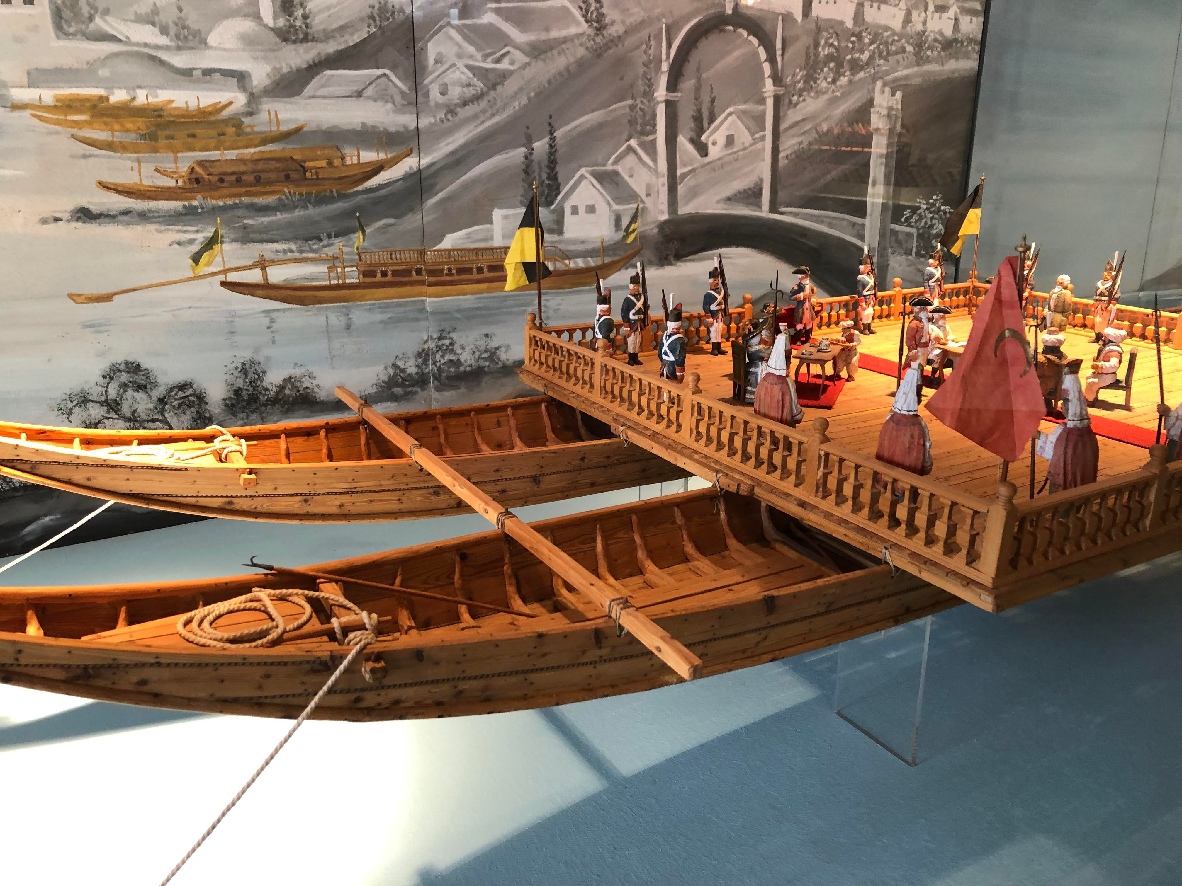 Modell eines historischen Schiffs mit Figuren in einem Museum.
