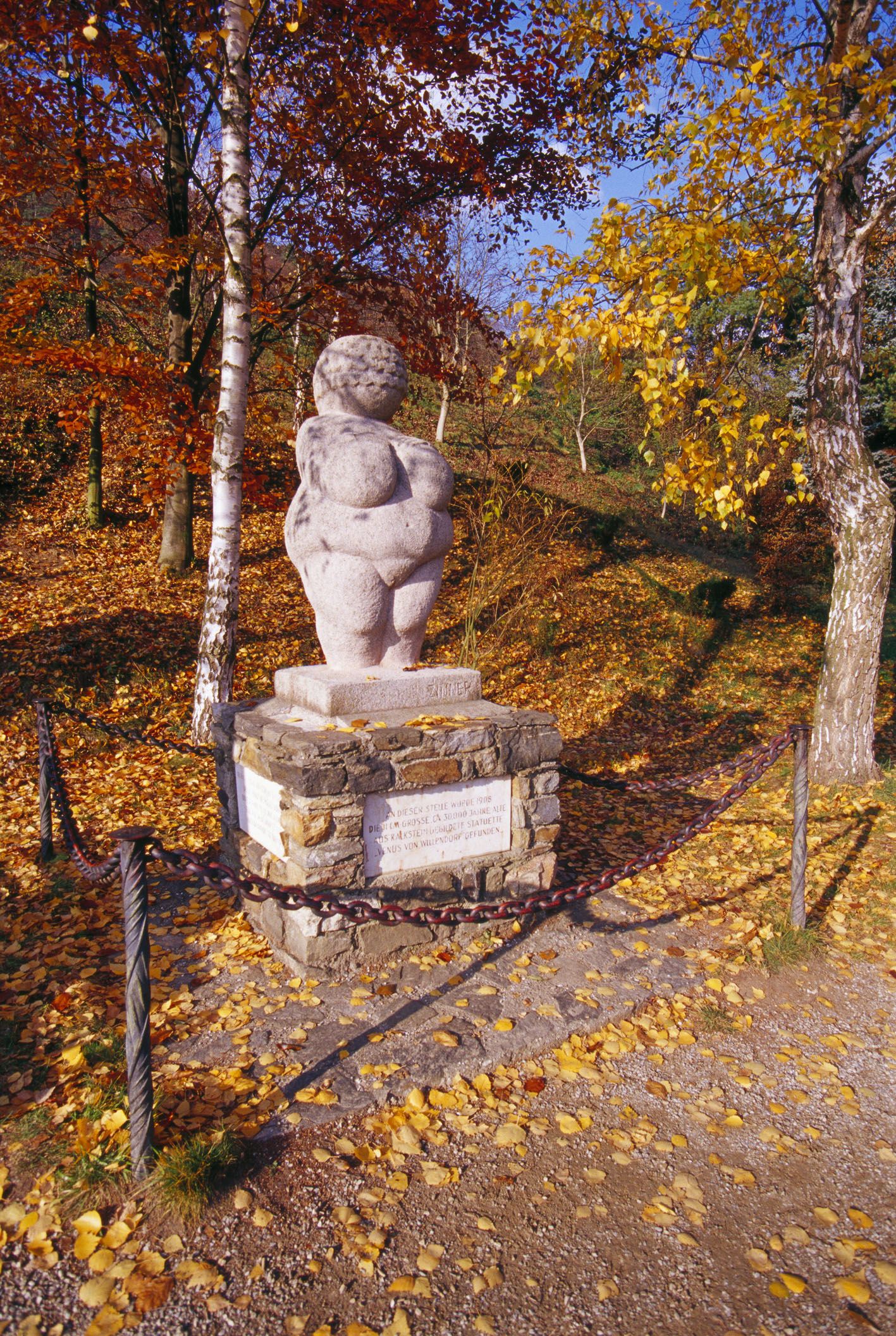 Venus am Sockel mit Herbstlaub darum herum