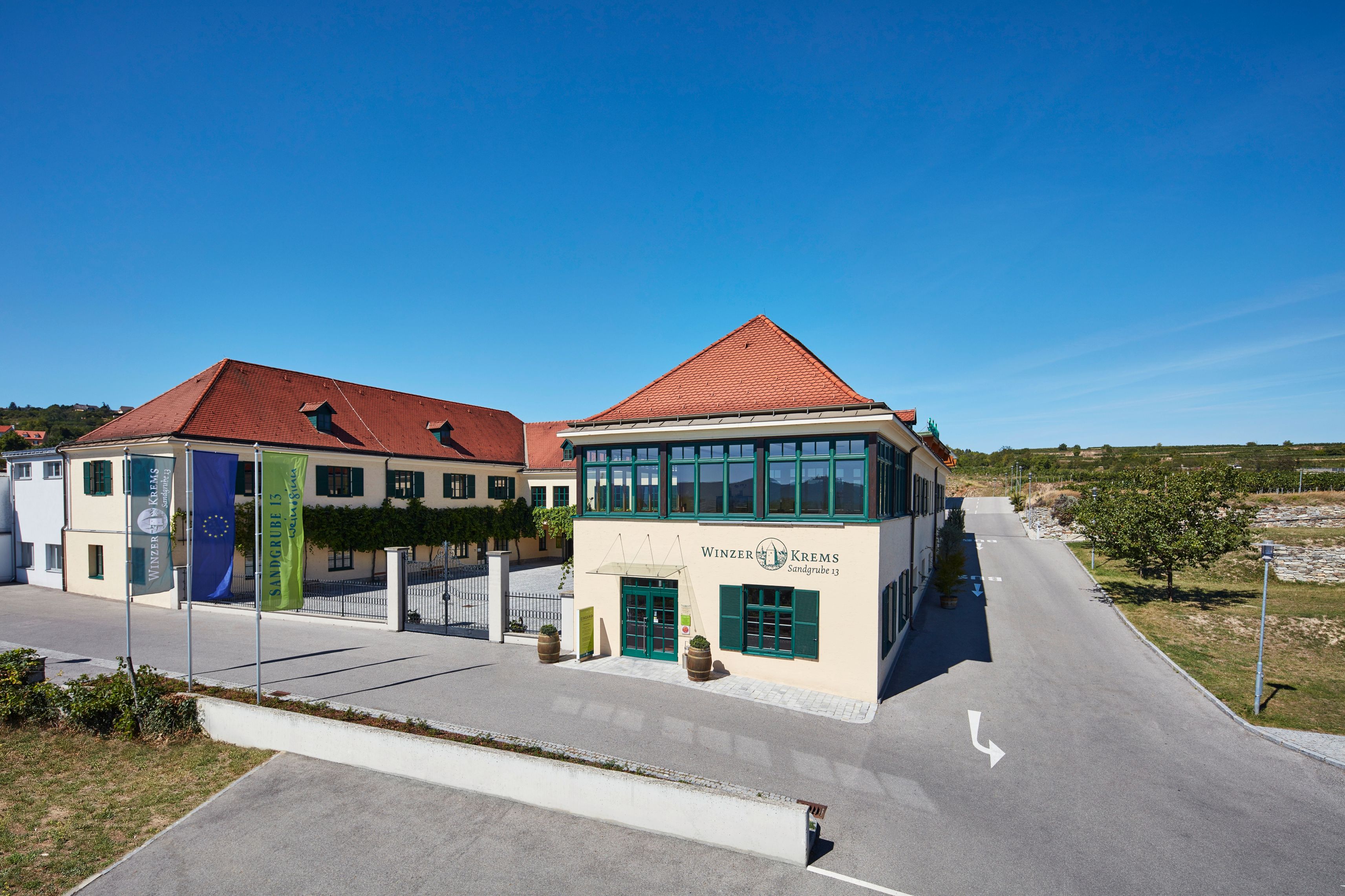 Gebäude von Winzer Krems mit roten Dächern und blauen Himmel.