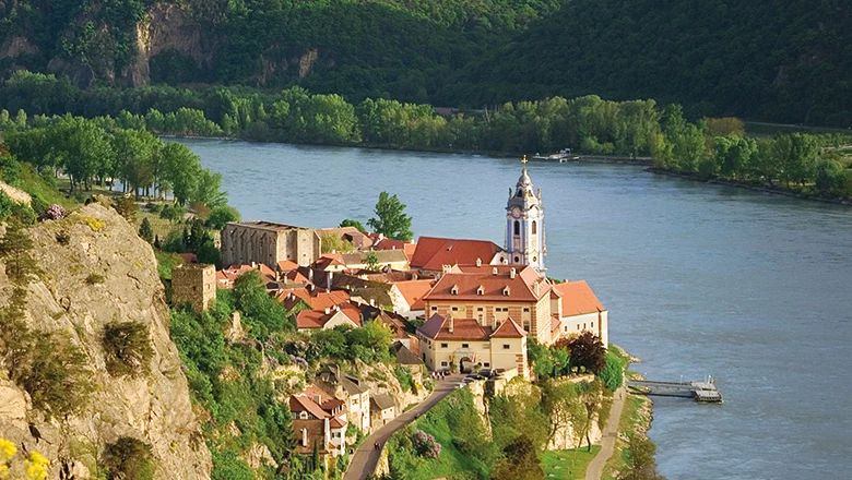 Blick von oben auf Dürnstein mit Stift, roten Dächern und Donau.