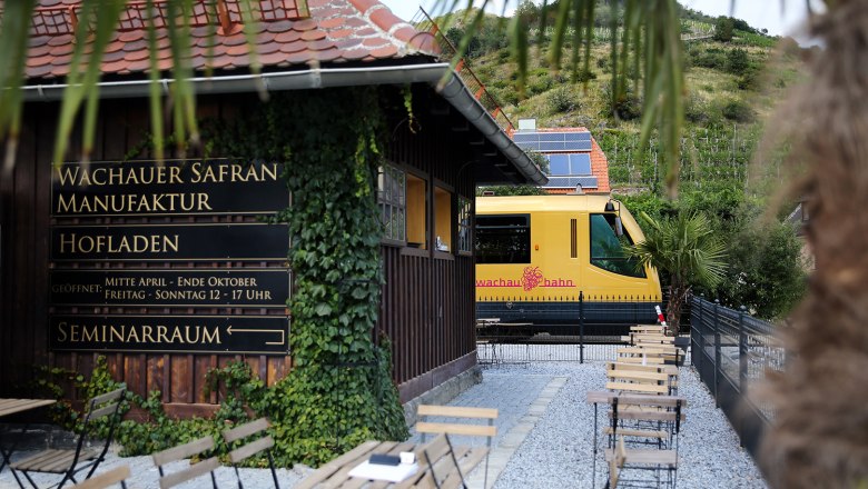 Die Wachaubahn steht im Bahnhof Dürnstein. Im Vordergrund ist das Gebäude der Safranmanufaktur zu sehen