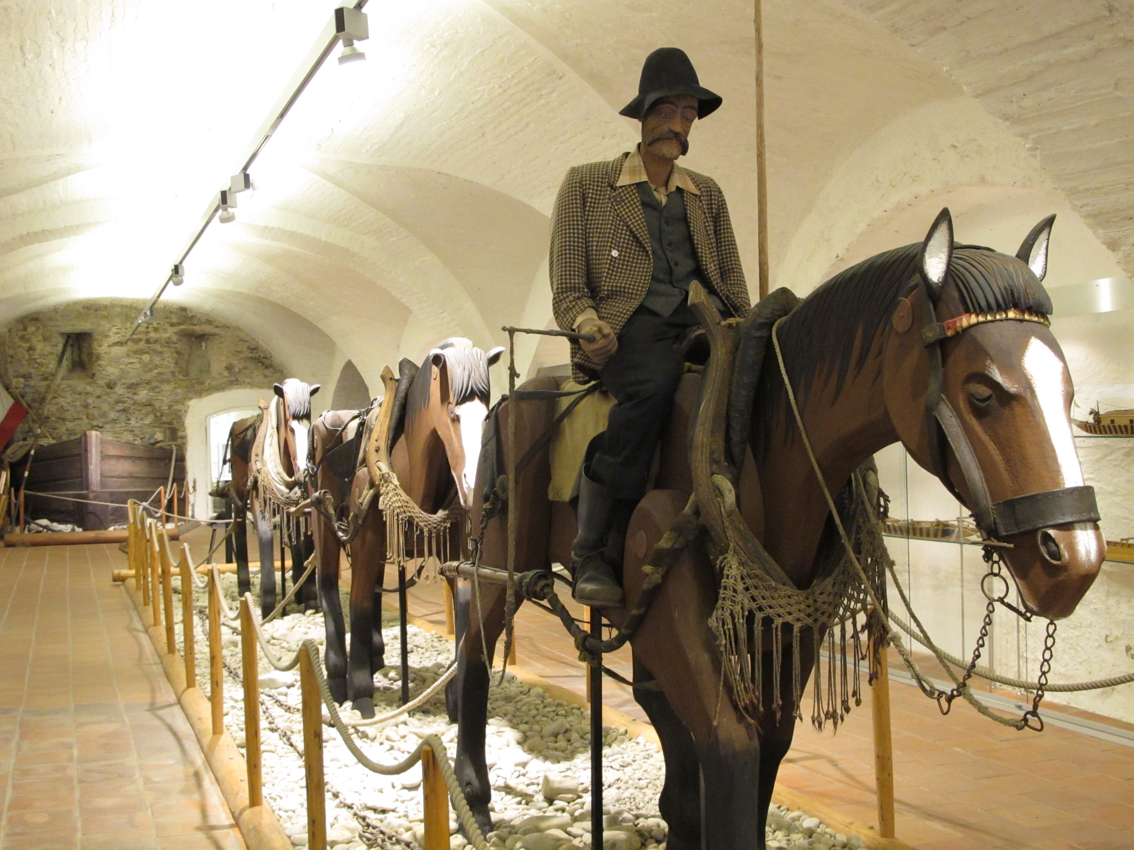 Ausstellungsobjekt im Schifffahrtsmuseum mit Figuren auf Holzpferden.
